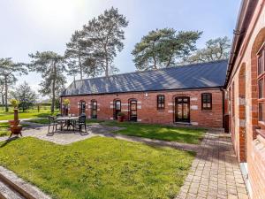 a brick building with a picnic table in the yard at Low Barn in Market Bosworth