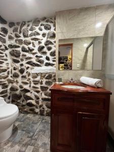 a bathroom with a sink and a stone wall at Luisa in Ollantaytambo