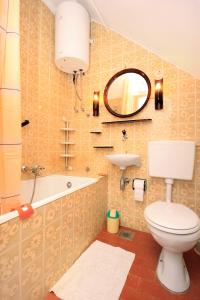 a bathroom with a toilet and a sink and a mirror at Seaside holiday house Sibenik - 6635 in Šibenik