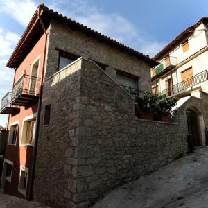 a stone building with two balconies on a street at Guest House Ioanna Arachova in Arachova