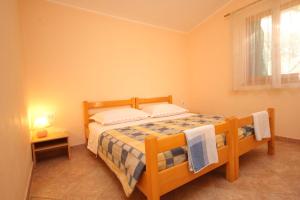a bedroom with a wooden bed in a room at Secluded fisherman's cottage Cove Magrovica - Telascica, Dugi otok - 8122 in Sali