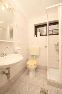 uma casa de banho com um WC, um lavatório e um chuveiro em Apartments with a parking space Artatore, Losinj - 8007 em Čunski