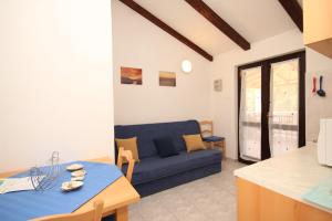 a living room with a blue couch and a table at Apartments with a parking space Artatore, Losinj - 8007 in Cunski