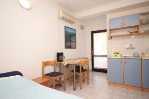 a room with a kitchen and a table with chairs at Apartments with a parking space Artatore, Losinj - 8007 in Cunski