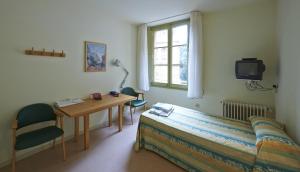 Una habitación con una cama, una mesa y un televisor. en Apartamentos Montserrat Abat Marcet, en Montserrat