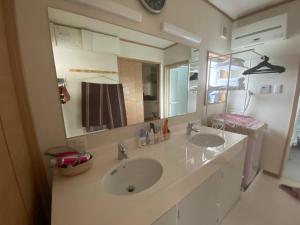 a bathroom with two sinks and a large mirror at 琵琶湖畔澄の宿 in Otsu