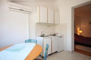 eine kleine Küche mit Tisch und Spüle in der Unterkunft Apartments with parking space Rovinj - 7656 in Rovinj