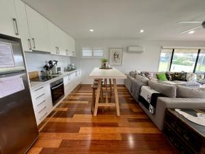 a kitchen and living room with a couch and a table at Perfect weekend getaway plus golf at your doorstep in Salamander Bay
