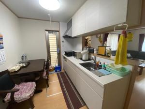 una pequeña cocina con fregadero y mesa en 琵琶湖畔澄の宿 en Otsu