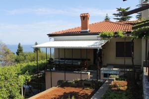 a house with an awning on the side of it at Rooms by the sea Medveja, Opatija - 7775 in Lovran