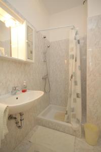 a white bathroom with a sink and a shower at Rooms by the sea Medveja, Opatija - 7775 in Lovran