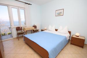 a bedroom with a bed and a table and chairs at Rooms by the sea Medveja, Opatija - 7775 in Lovran