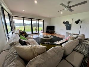 una sala de estar con 2 personas en un sofá en Perfect weekend getaway plus golf at your doorstep, en Salamander Bay