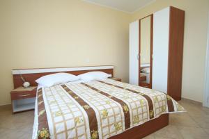 een slaapkamer met een bed en een tafel met een spiegel bij Double Room Medveja 7775d in Lovran