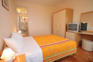 Dormitorio pequeño con cama y TV en Double Room Medveja 7775b en Lovran