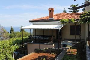 a house with an awning on the side of it at Double Room Medveja 7775a in Lovran