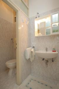 ein Badezimmer mit einem Waschbecken, einem WC und einem Spiegel in der Unterkunft Double Room Medveja 7775a in Lovran