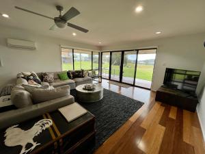 a living room with a couch and a tv at Perfect weekend getaway plus golf at your doorstep in Salamander Bay
