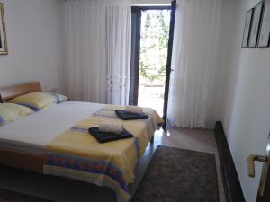a bedroom with two beds and a large window at Apartments with a parking space Zavala, Hvar - 8706 in Jelsa