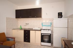 a kitchen with a white refrigerator and a stove at Apartments by the sea Basina, Hvar - 8749 in Vrbanj