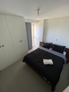 um quarto com uma cama grande e um edredão preto em Villi 503C em João Pessoa