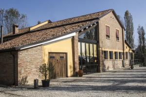 an old brick building with a large door at Corte Dossello in Migliaro