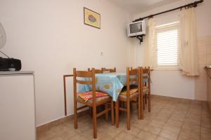 a dining room with a table and chairs and a tv at Apartments by the sea Vis - 2477 in Vis