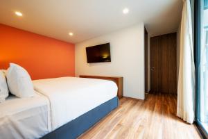 a hotel room with a bed and a window at Capitalia - Apartments - CÉFIRO CINCO in Mexico City