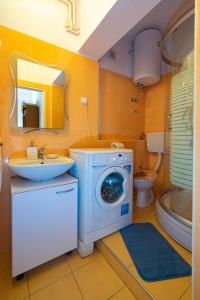 ein Badezimmer mit Waschmaschine und Waschbecken in der Unterkunft Apartments with parking space Bibinje, Zadar - 18275 in Bibinje