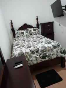 Schlafzimmer mit einem Bett mit einer schwarzen und weißen Bettdecke in der Unterkunft Sosua Apartment 4-Bedrooms in Sosúa