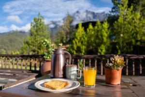 - une table avec une cafetière, du pain grillé et du jus d'orange dans l'établissement Sweeping Mountain View Retreat at La Cantane Villa, à Kampong Kundassan