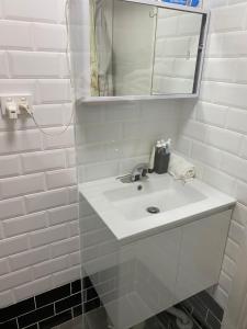 a white bathroom with a sink and a mirror at Central of CBD in Sydney