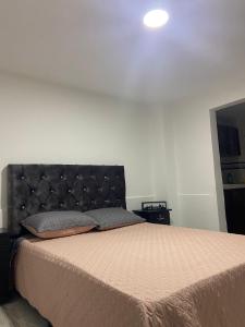 1 dormitorio con 1 cama grande y cabecero negro en Aparta estudio, en Filandia