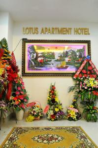 a sign for a louis apartment hotel with flowers on a wall at Lotus Apartment Hotel in Vung Tau