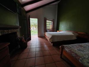 1 Schlafzimmer mit 2 Betten und einem Kamin in der Unterkunft Hotel Villa Zurqui in San José