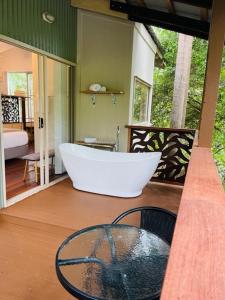 uma grande banheira sentada num alpendre com em Kondalilla Eco Resort em Montville
