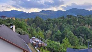 Chalés Mirante Monte Verde في مونتي فيردي: منزل في وسط غابة مع جبال +33 صورة