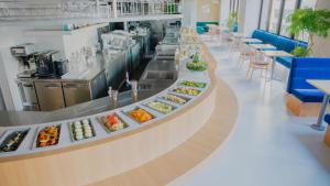 a restaurant with a buffet line with plates of food at JR-East Hotel Mets Shibuya in Tokyo