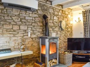 a stone wall with a wood stove in a room at The Cart House in Merthyr Cynog