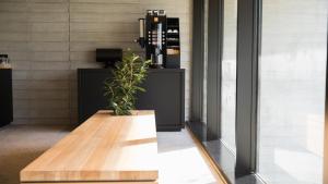 a potted plant sitting on a wooden bench in a lobby at JR-East Hotel Mets Tokyo Bay Shinkiba in Tokyo