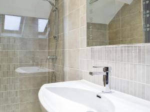 a bathroom with a white sink and a mirror at The Cart House in Merthyr Cynog