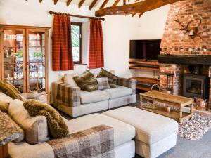 a living room with two couches and a fireplace at Lodge Farm Barn in South Walsham