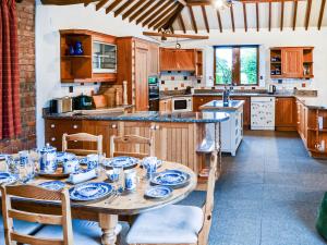 a kitchen with a table with blue and white dishes on it at Lodge Farm Barn in South Walsham