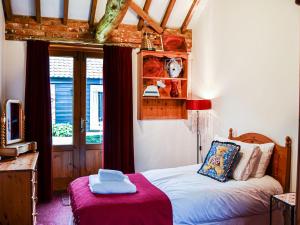 a small bedroom with a bed and a window at Lodge Farm Barn in South Walsham