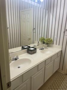 a bathroom with two sinks and a large mirror at Unwind and Relax 4 Bedroom Stay in Humble