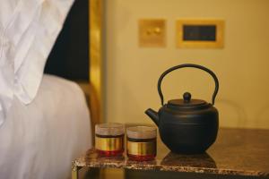 a tea pot and two candles on a table next to a bed at The Vices York in York