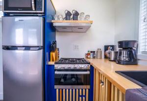 a kitchen with a refrigerator and a stove at Cozy modern tiny home near ZION & private deck in Apple Valley