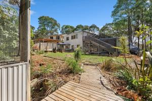 een huis met een houten loopbrug voor een tuin bij Wave Haven in Dalmeny