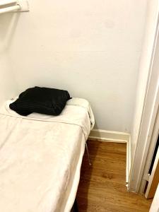 a small bed in a corner of a room at The Ugly House in Houston
