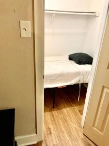 a small bed in a small room with a closet at The Ugly House in Houston